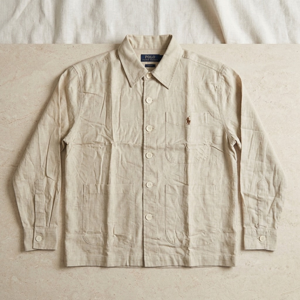 Beige button-up overshirt with three patch pockets, long sleeves and embroidered chest motif
